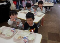 給食を食べる幼児の写真