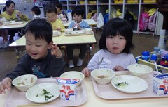 給食を食べる幼児の写真