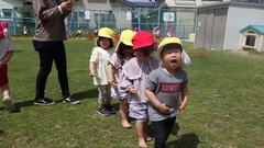 芝生園庭で遊ぶ幼児の写真