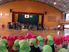 小学生の演奏を聞く幼児の写真