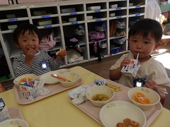 給食を食べる幼児の写真