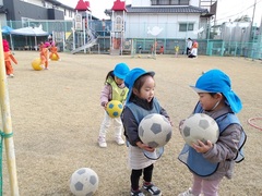 サッカーごっこをする幼児の写真