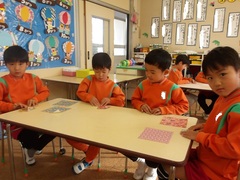 折り紙をする5歳児の写真