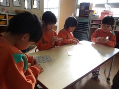 折り紙をする5歳児の写真