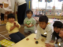 コマで遊ぶ幼児の写真
