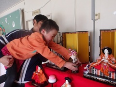 雛人形を飾る幼児の写真