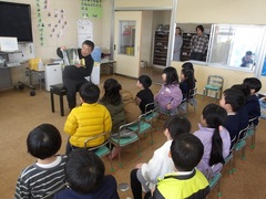 読み聞かせを聞く幼児の写真