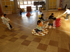 お寿司を背負って遊ぶ幼児の写真