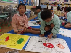 獅子舞の絵を描く幼児の写真
