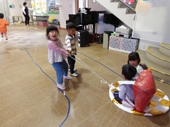 お寿司を背負って遊ぶ幼児の写真