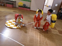 お寿司を背負って遊ぶ幼児の写真