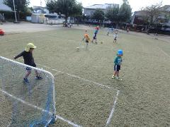 芝生でサッカーを楽しむ様子（1）