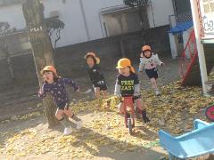 落ち葉の上を走る子供たち