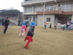 芝生で遊ぶ幼児と児童