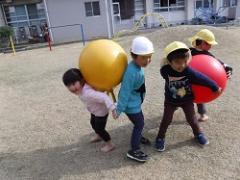 大きなボールで遊ぶ幼児