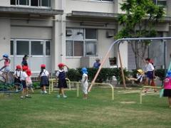 芝生で遊ぶ幼児と児童