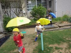 傘を差して歩く3歳児