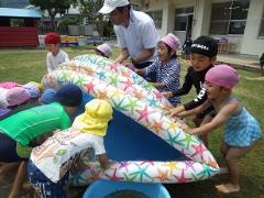 水遊びの片付けをする幼児