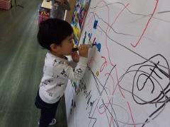 ホワイトボードに絵を描く幼児