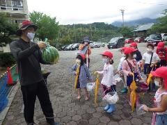 いただいたスイカを見せてもらう幼児