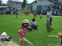 芝生で座って話す保護者達