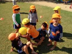 ラグビーボールで遊んでいる幼児の姿