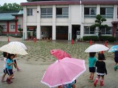 雨の中芝生の周りを散歩する幼児