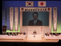 写真：地区年次大会で挨拶する松山市長
