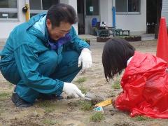 写真：園児と一緒に芝生の苗を植える松山市長