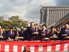 餅まきする市長