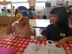 自分で作ったカラフルなめがねを使って遊ぶことを楽しむ子どもたち