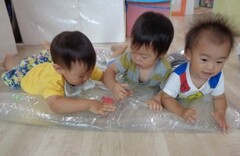 ウォーターマットの上で遊ぶ１歳児
