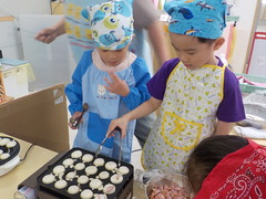 たこ焼き器を使ってホットケーキを作る子どもたちの写真