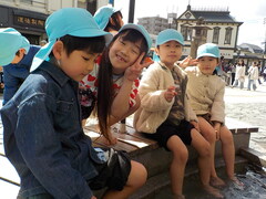 道後で足湯をしている子どもたちの写真