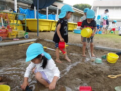 砂場でどろんこ遊びをしている子どもたちの様子