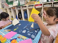 折り紙を折ったり切ったりして制作を楽しむ子どもたちの様子