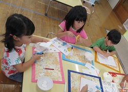 子どもたちがお店屋さんごっこで使うお金を製作している写真