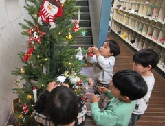 クリスマスツリーの飾り付けをする子どもたちの写真