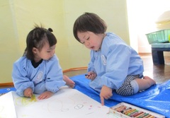 １歳児がクレヨンで絵を描いている写真