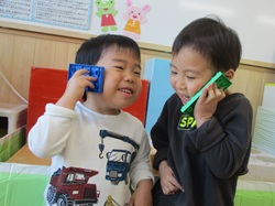 2歳児が電話ごっこをしている写真