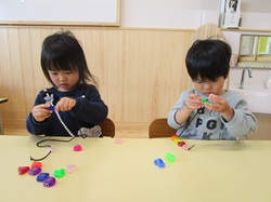 2歳児がひも通しをしている写真