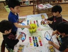 5歳児が絵の具を使って絵を描いている写真