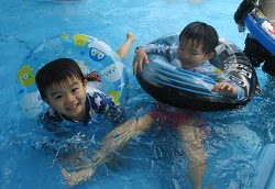 ４歳児がプールで浮き輪で遊んでいる写真