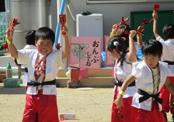 5歳児が鳴子を持って踊っている写真