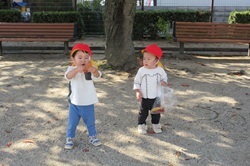 1歳児が落ち葉を拾っている写真