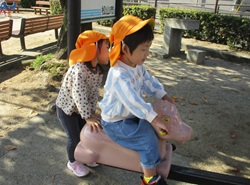 3歳児が公園の動物型のシーソーに乗っている写真