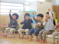3歳児が進級式で手あそびしている写真