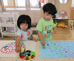 ３歳児が野菜スタンプをしている写真