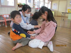 ふれあい遊びを楽しむ1歳児と5歳児の写真