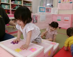 0歳児が階段の遊具を登っている写真